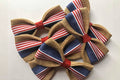 Four decorative pet bow ties with red, white, and blue patterns on a light background.|Quatre nœuds papillon décoratifs pour animaux, à motifs rouges, blancs et bleus sur fond clair.