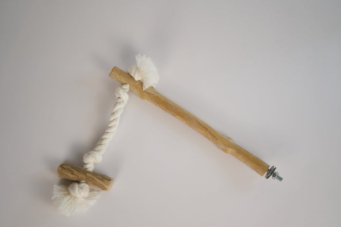Wooden bird perch with a cotton rope suspending a bird swing.|Perchoir pour oiseaux en bois avec corde en coton qui suspend une balancoire à oiseau.
