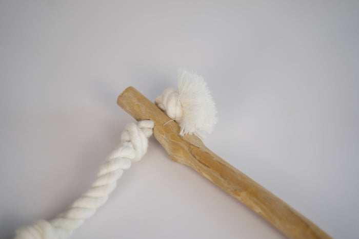Close-up view of the cotton rope attached to the bird perch.|Vue rapprochée de la corde en coton attachée au perchoir d'oiseau.