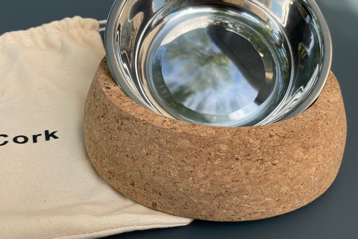 Cork base with a metal bowl for pets on a gray background.|Base en liège avec un bol en métal pour animaux de compagnie sur fond gris.