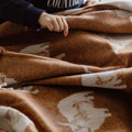 Person wearing a navy sweatshirt with 'COUNTRY' text, interacting with a brown fabric with white patterns.