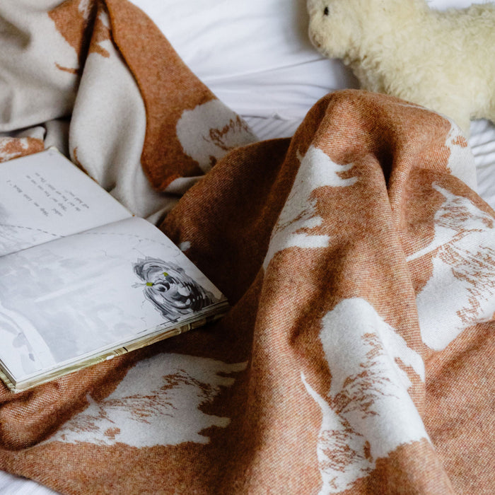 Open book on a white pillow with a brown patterned blanket