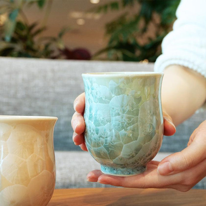 Hands holding a crystal-glazed yunomi Japanese tea cup in green | Kyoto-Kiyomizu ware, Touan