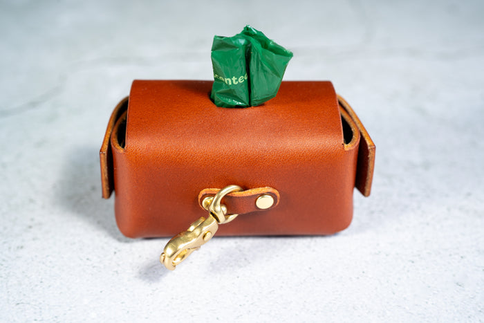 Rear view of the chestnut leather dog poop bag holder and the dog leash clip. | Vue arrière du support de sac à crottes de chien en cuir marron et de l'attache pour la laisse.