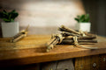 Bundles of sticks for cats tied together on a wooden surface with a blurred indoor background.|Des fagots de bâtons pour chats sont attachés ensemble sur une surface en bois, avec un arrière-plan intérieur flou.