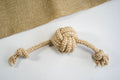 Monkey fist ball for dogs made of cotton rope and sisal with knots at the ends. | Balle de poing de singe pour chiens en corde de coton et sisal avec noeuds aux extrémités.