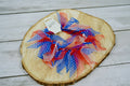 Red, white, and blue polka dot ribbons pet collar on a wooden surface.|Collier pour animal avec rubans à pois rouges, blancs et bleus, posé sur une surface en bois.