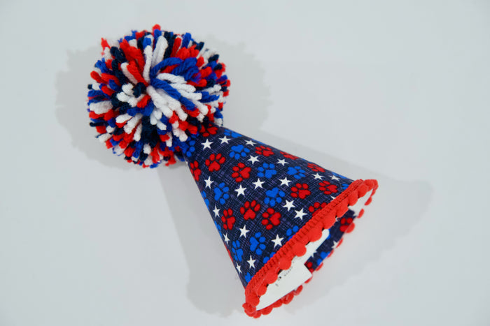 Pet party hat with red, white, and blue design on a light gray background.|Chapeau de fête pour animal, avec un motif rouge, blanc et bleu sur fond gris clair.