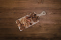 Assorted freeze-dried treats for dogs on a snack format charcuterie board.|Un assortiment de friandises lyophilisées pour chiens, présenté sur un plateau de type « charcuterie » au format snack.