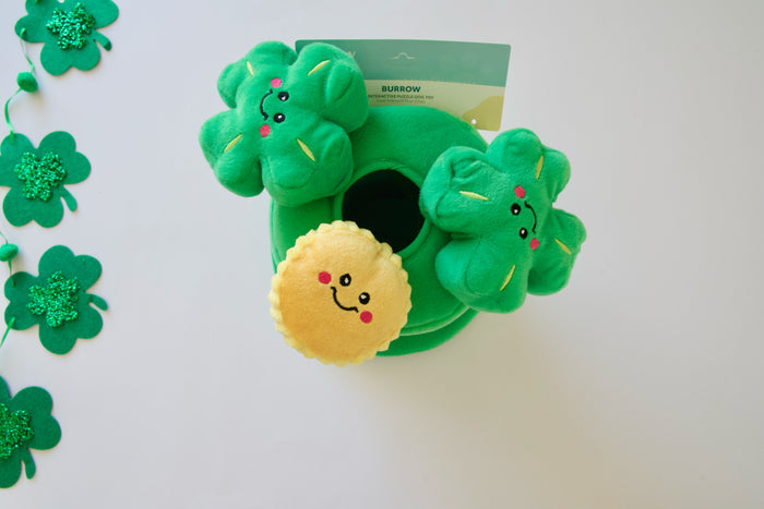 Top view of the leprechaun's hat dog plush toy with clover designs on a white background.|Top view of the leprechaun's hat dog plush toy with clover designs on a white background.