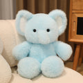 Light blue teddy bear sitting on a white surface with a neutral background