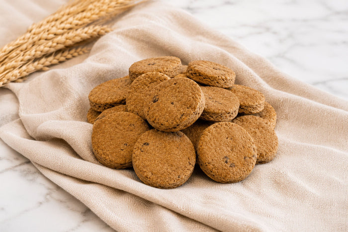 Close-up of Baxter Bailey Wild Blueberry Biscuits, gluten-free dog treats made with wholesome ingredients and baked in small batches.|Gros plan sur les biscuits aux myrtilles sauvages pour chiens sans gluten faits d'ingrédients sains et cuits en petites quantités.